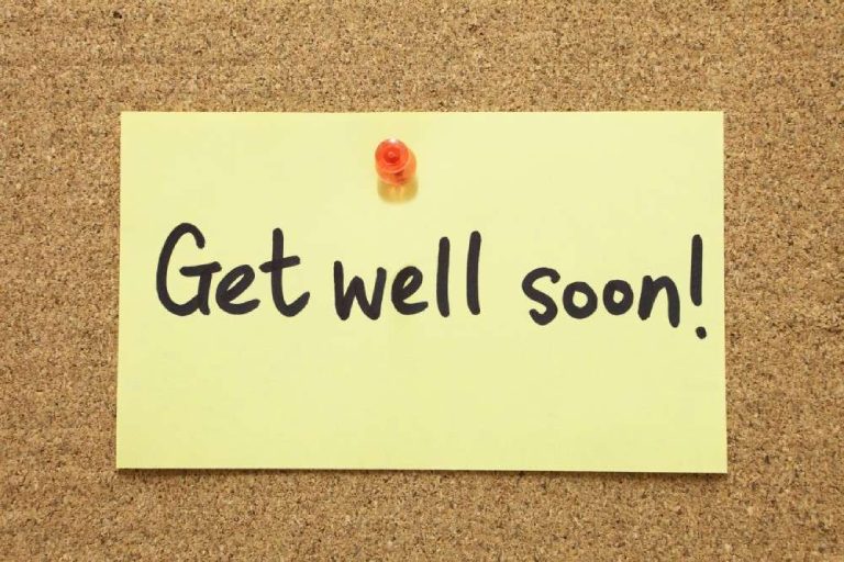 A sticky note on a cork board that reads "get well soon"